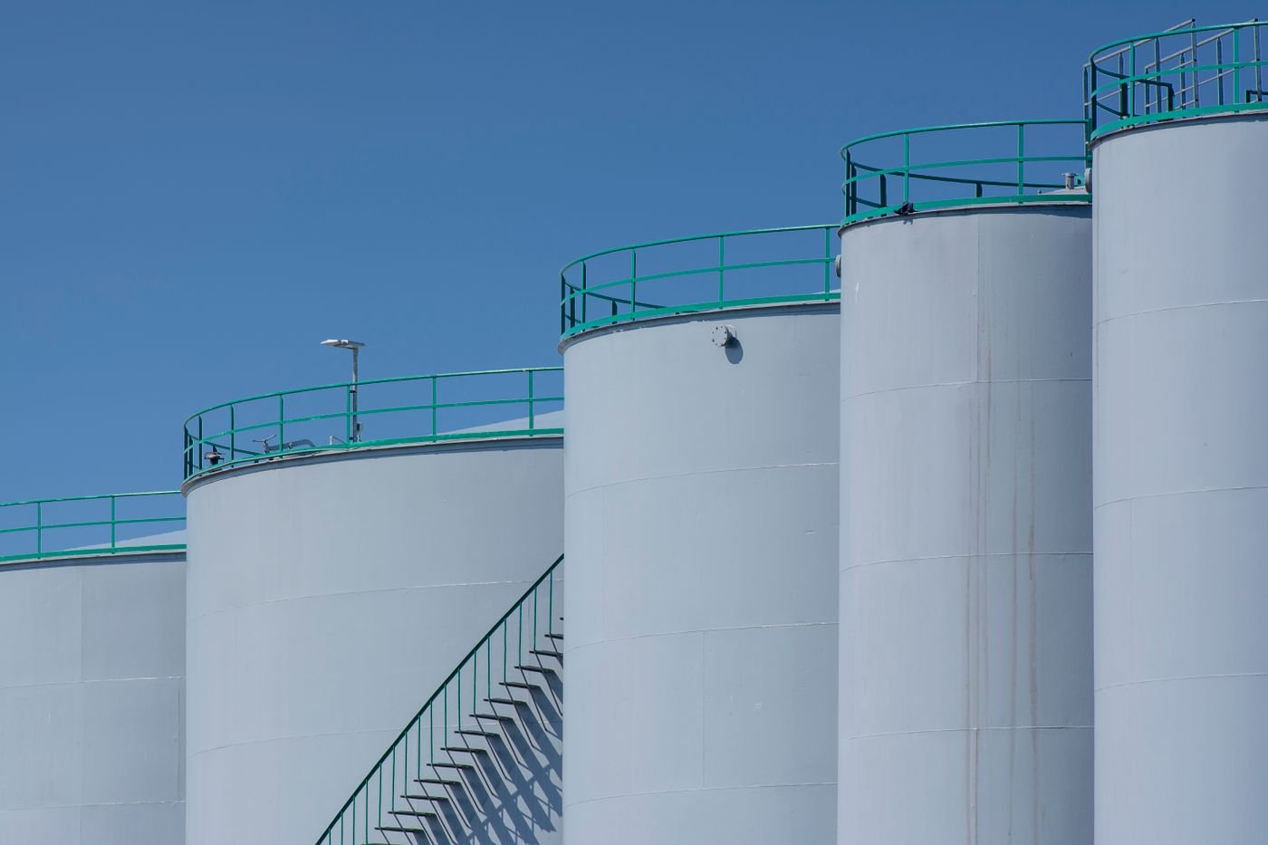 Vertical storage tanks against a blue sky
